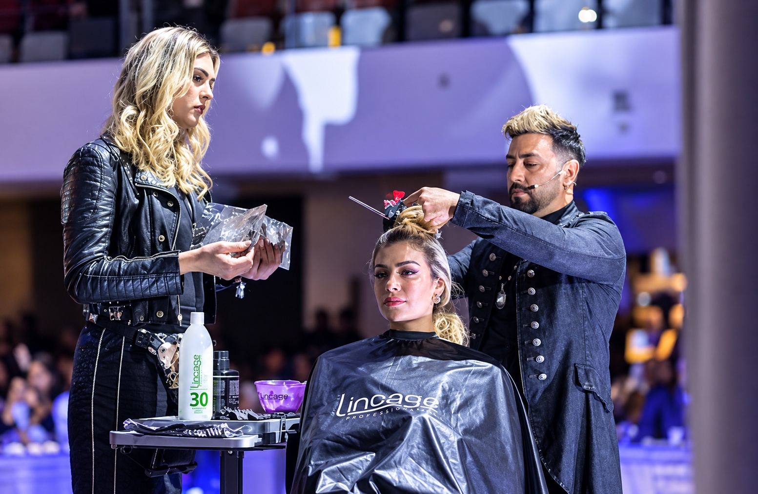 Ariel Cubas styling a model on stage during a live hair demonstration
